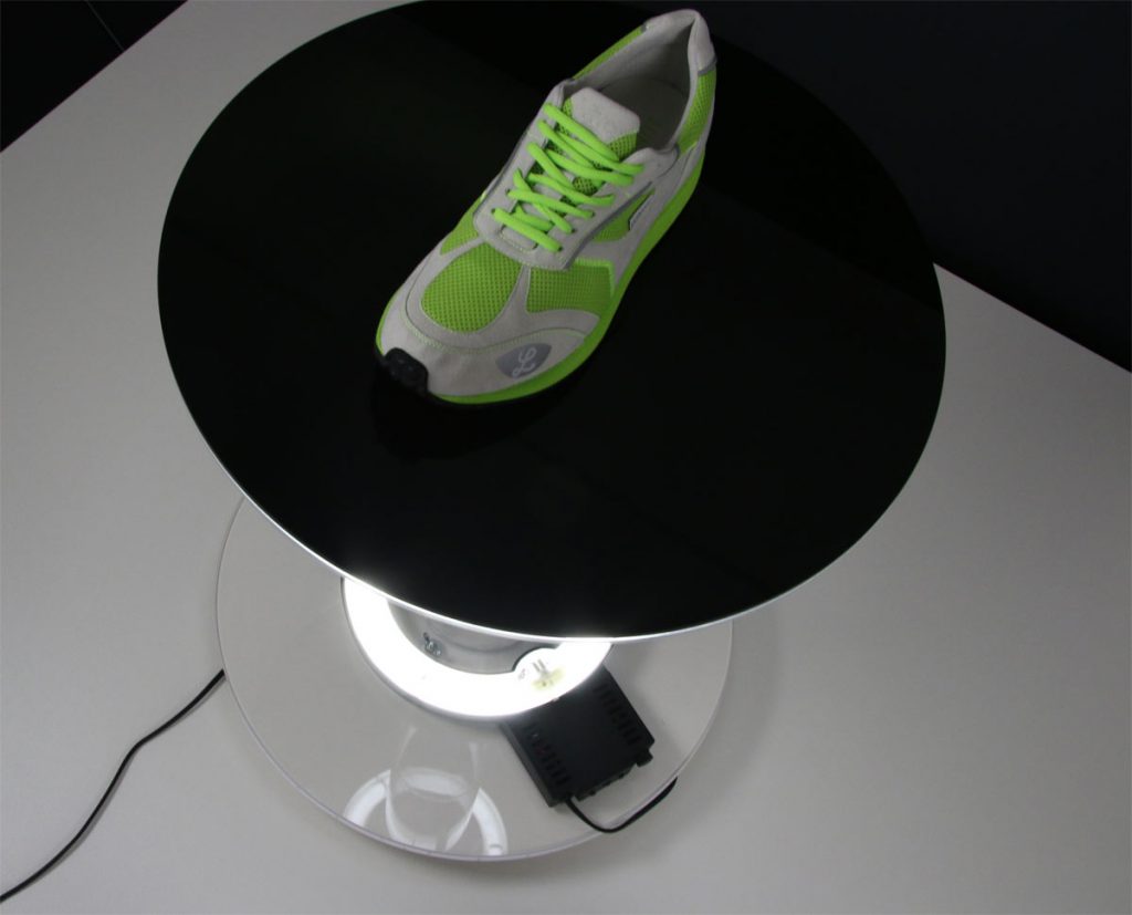 Laufschuh auf schwarzer Plexiglasscheibe mit Beleuchtung von unten
